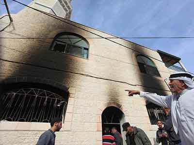 مستوطنون يضرمون النيران في مسجد ويكتبون شعارات عنصرية على جدرانه