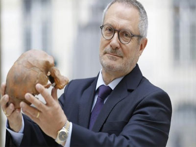 العالم الفرنسي جان جاك اوبلان يحمل جمجمة مكتشفة في المغرب لأحد الاسلاف